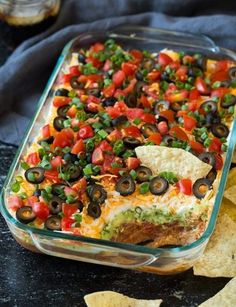 a glass casserole dish filled with black olives, tomatoes and green peppers