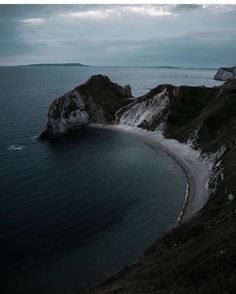 an empty beach on the side of a cliff