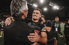 two rugby players hug each other on the field