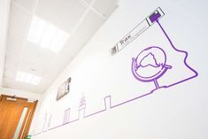 an office with white walls and purple graphics on the wall