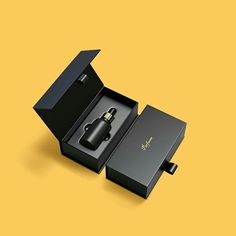 an open black box with a plug in it on a yellow background and the lid opened