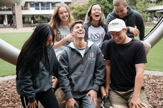 a group of young people sitting on top of a metal slide next to each other