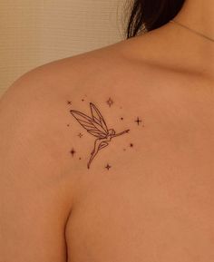 the back of a woman's shoulder with a small tattoo on it