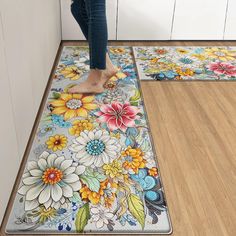 a woman standing on the floor in front of two mats with flowers painted on them