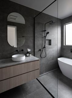 a bathroom with a sink, mirror and bathtub next to a window in it