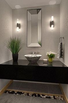 a bathroom with a sink, mirror and plants on the counter in front of it