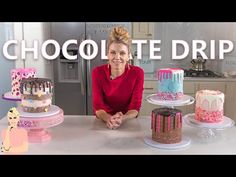 a woman sitting in front of three cakes on top of a counter next to a refrigerator