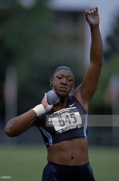 a female athlete is holding her hand up in the air while talking on a cell phone