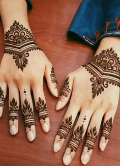 two hands with henna tattoos on them