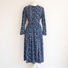 A super cute cottagecore style 1980s Laura Ashley floral dress. Long sleeves, pockets, midi length. The dress buttons at the front from the waist to the neck. Also 3 buttons at each cuff. Blue piping around the waistline, round the neck and down the front. Zip at the side.  No flaws to note. Excellent condition. 83% cotton 17% wool UK 10-12 Waist: 30" Bust: 38" Length: approx 47" ♥ SHIPPING ♥ * International postage - these costs are estimates, and I will happily refund any excess postage you ma Cottagecore Long Sleeve Vintage Dress With Floral Print, Spring Vintage Button-up Midi Dress, Vintage Button-up Midi Dress For Spring, Floral Dress Long, Cute Cottagecore, Vintage Laura Ashley, Dress Buttons, Cottagecore Style, Dress Long Sleeves