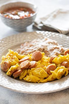 a white plate topped with scrambled eggs and sausage