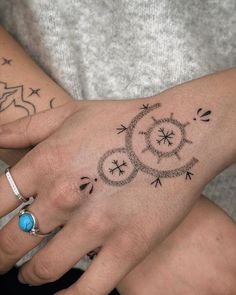 two people with tattoos on their hands holding each other