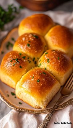 four rolls on a plate with a fork