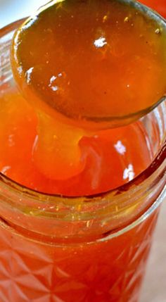 a spoon full of liquid sitting on top of a jar