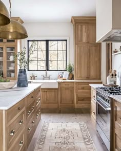 a large kitchen with wooden cabinets and white counter tops, along with an area rug on the floor