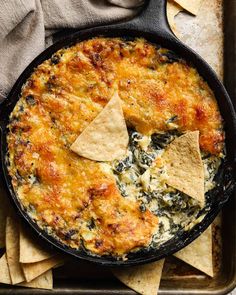 spinach dip with tortilla chips in a cast iron skillet