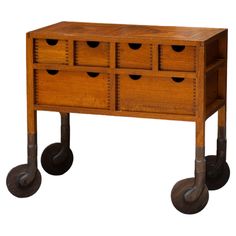 a wooden table with four drawers on wheels