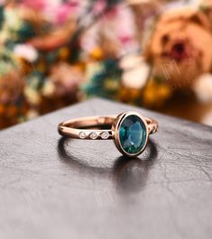 a close up view of a ring on a table with flowers in the back ground