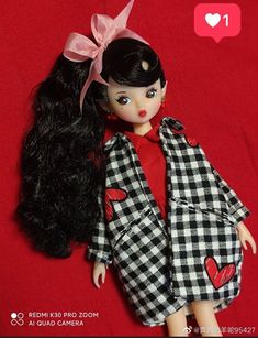 the doll is wearing a black and white checkered coat