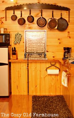 a kitchen with pots and pans hanging on the wall next to a stove top oven