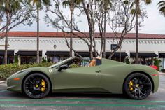 a green sports car parked in front of a building