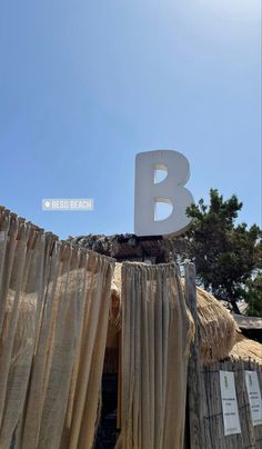 a sign that is on top of a wooden structure with drapes hanging from it's sides