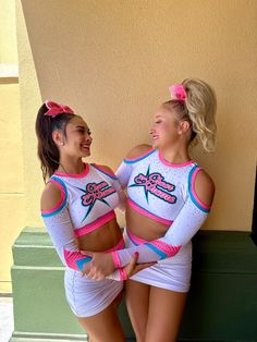 two girls in cheerleader outfits standing next to each other