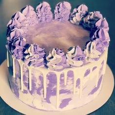 a purple and white cake with icing on top