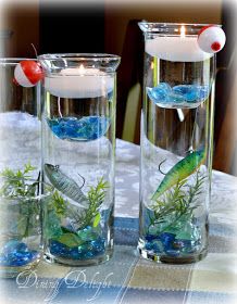 two clear vases filled with water and fish floating in them on top of a table