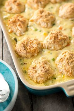 a casserole dish with meatballs and cheese in it on a wooden table