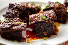 some brownies are sitting on a plate with sauce