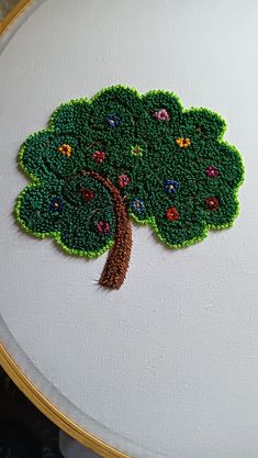 an embroidered tree is shown on a white surface