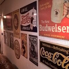 there are many signs on the wall in this room that is decorated with coca - cola