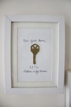 a white frame with a key hanging from it