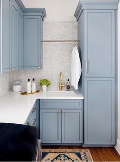 a kitchen with blue cabinets and white counter tops