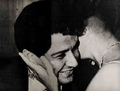 black and white photograph of a man holding his hand to his face next to a woman's head