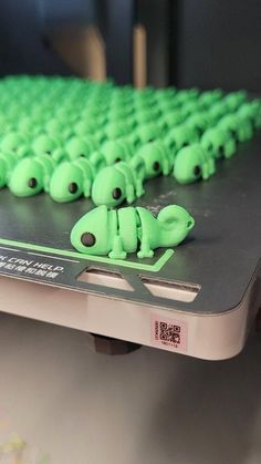 there are many green plastic animals on the computer keyboard that is made to look like alligators