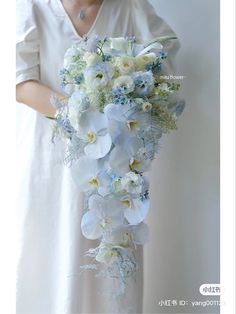 a woman holding a bouquet of white and blue flowers