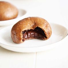 a chocolate filled doughnut on a white plate