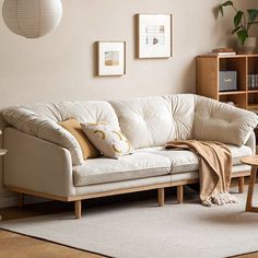 a living room with a white couch and coffee table in front of a book shelf