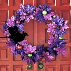 a purple wreath is hanging on the front door