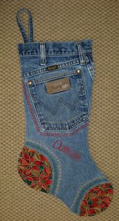 a pair of blue jeans with red flowers on the bottom and an embroidered pocket in the middle