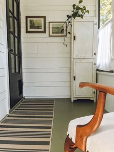 a room with a bed, rug and white cupboards in front of the door