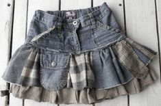 a denim skirt with ruffles on the bottom is laying on a wooden floor