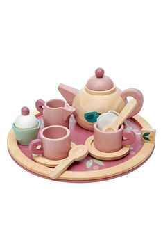 a pink tea set on a wooden tray