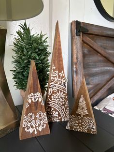 three wooden christmas trees sitting on top of a table