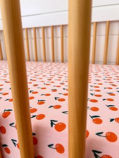 an orange and green polka dot crib sheet with wooden sticks sticking out of it