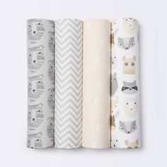 four baby swaddles are lined up next to each other