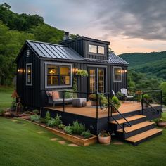 a small black house sitting on top of a lush green field