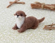 a small stuffed animal sitting on top of a floor next to sticks and twigs in front of it